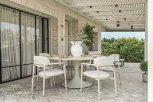שולחן אוכל לגינת הבית בעיצוב מודרני עם כיסאות תואמים במרפסת מקורה