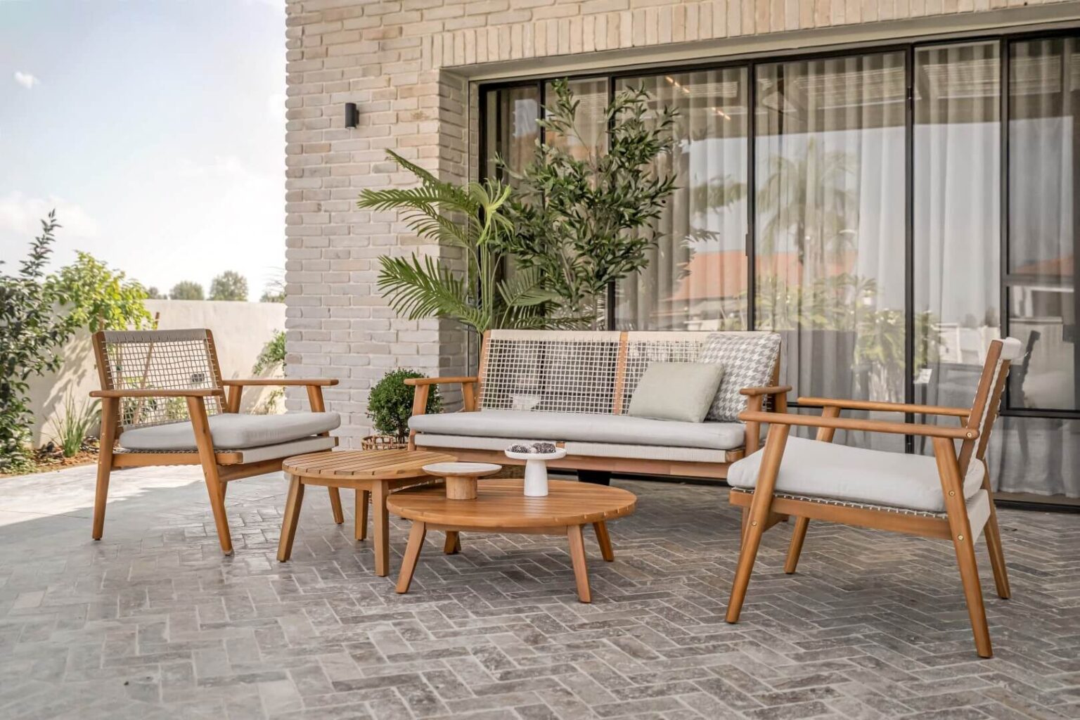 פינת ישיבה מעוצבת למרפסת עם ספה וכורסאות עץ בעיצוב מודרני