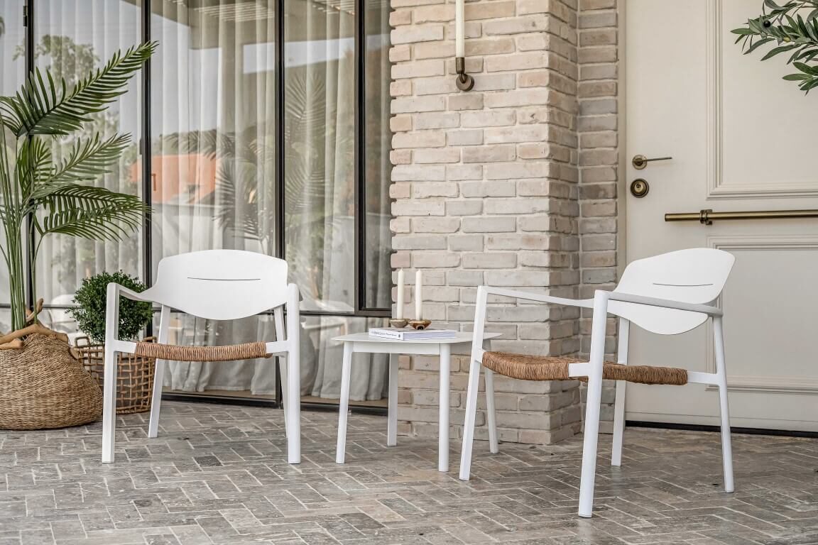 כורסאות גן מעוצבות עם שולחן צד במרפסת ביתית